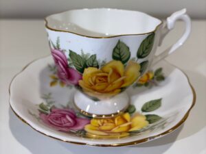 Side profile of an vintage floral teacup on a saucer illustrating proper pedestal foot balance and handle alignment